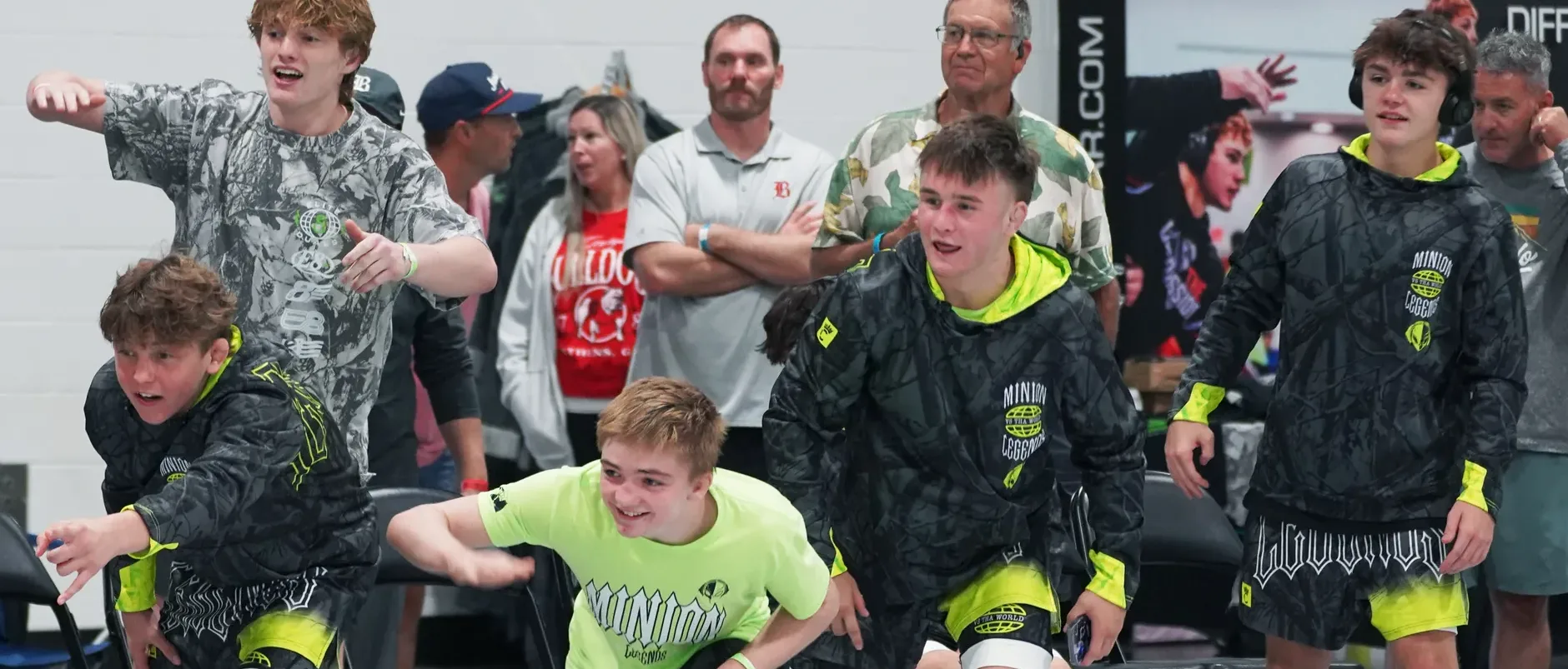 A team bench on its feet cheering in matching lime and black gear